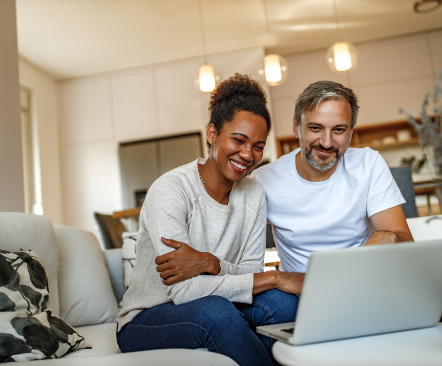 vrolijke man en vrouw met laptop in huiselijke setting